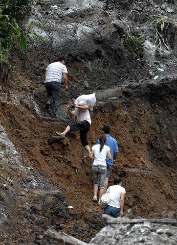 7月23日,几名群众经过造成29人失踪的安康市平台汉滨区七堰村滑坡现场。新华社记者 丁海涛 摄