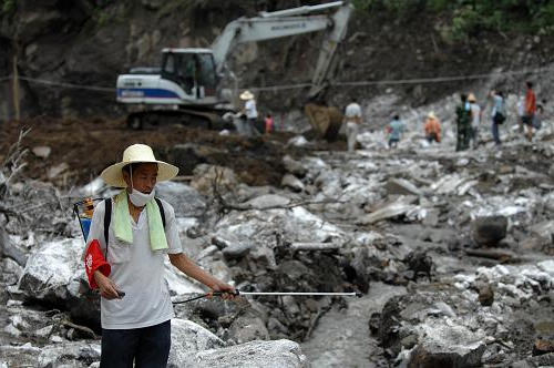 7月23日,在造成29人失踪的安康市平台汉滨区七堰村滑坡现场,一位防疫人员在喷洒消毒水。新华社记者 丁海涛 摄